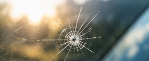 Small chip with radiating cracks in a windshield